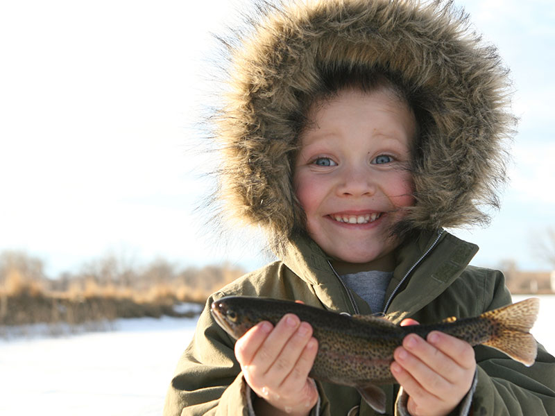 excited young boy holding a fish